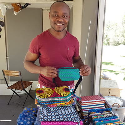 Mewa Ngongang with his shwe shwe fabric laptop bags, pencil cases, bags and notebooks